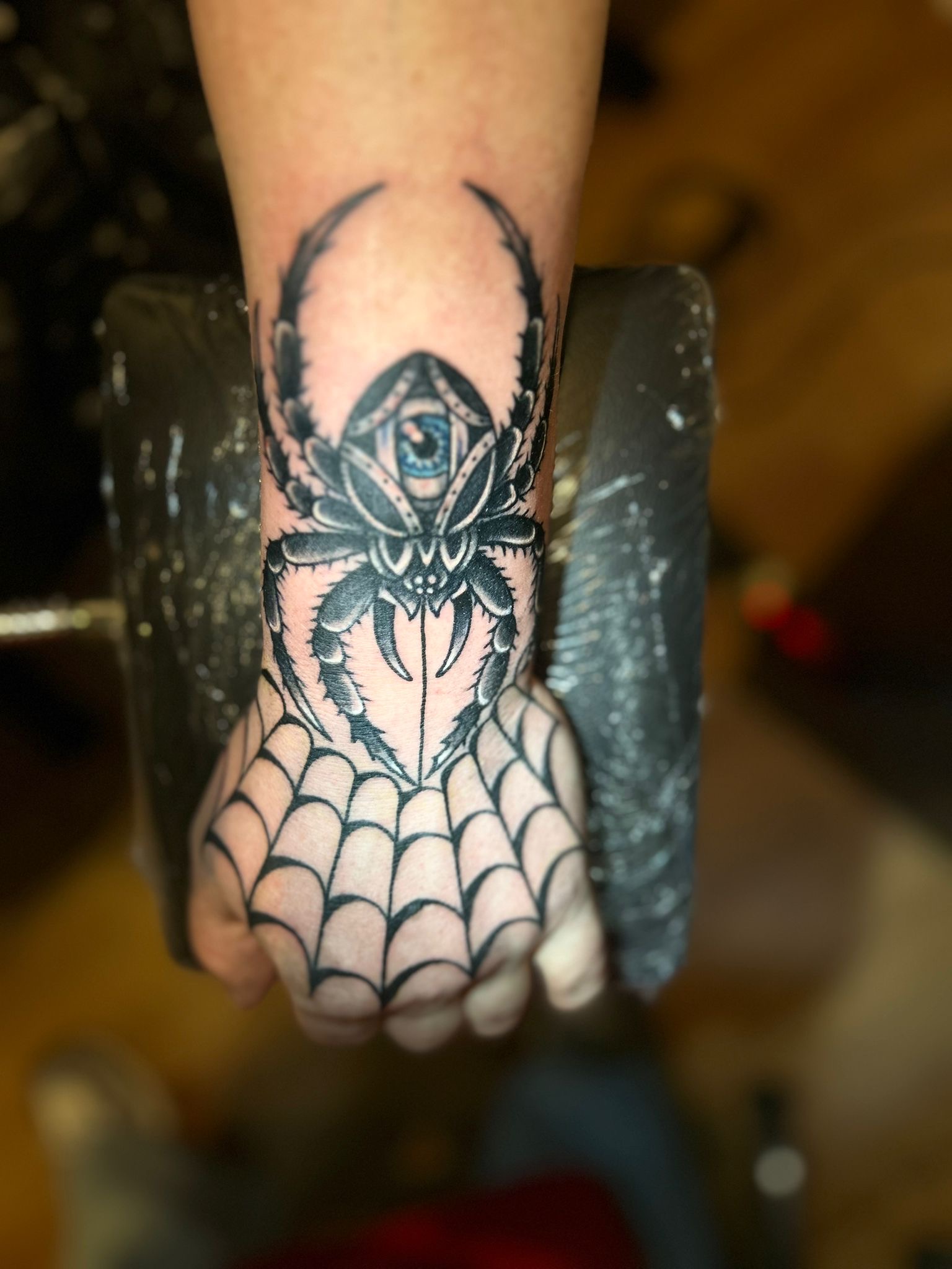 Spinnen-Tattoo mit Netz auf der Hand